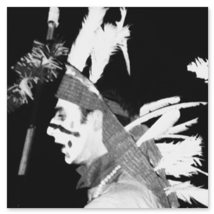 Foto storica in bianco e nero di Simone Mabellini a 22 anni, Capo Scout in veste da indiano durante il rito notturno di assegnazione del Totem attorno al fuoco.